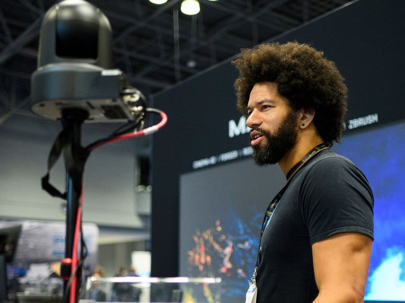 A broadcast exhibitor is presenting on the show floor.