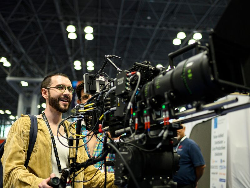 A person is testing out a broadcast camera on the show floor.