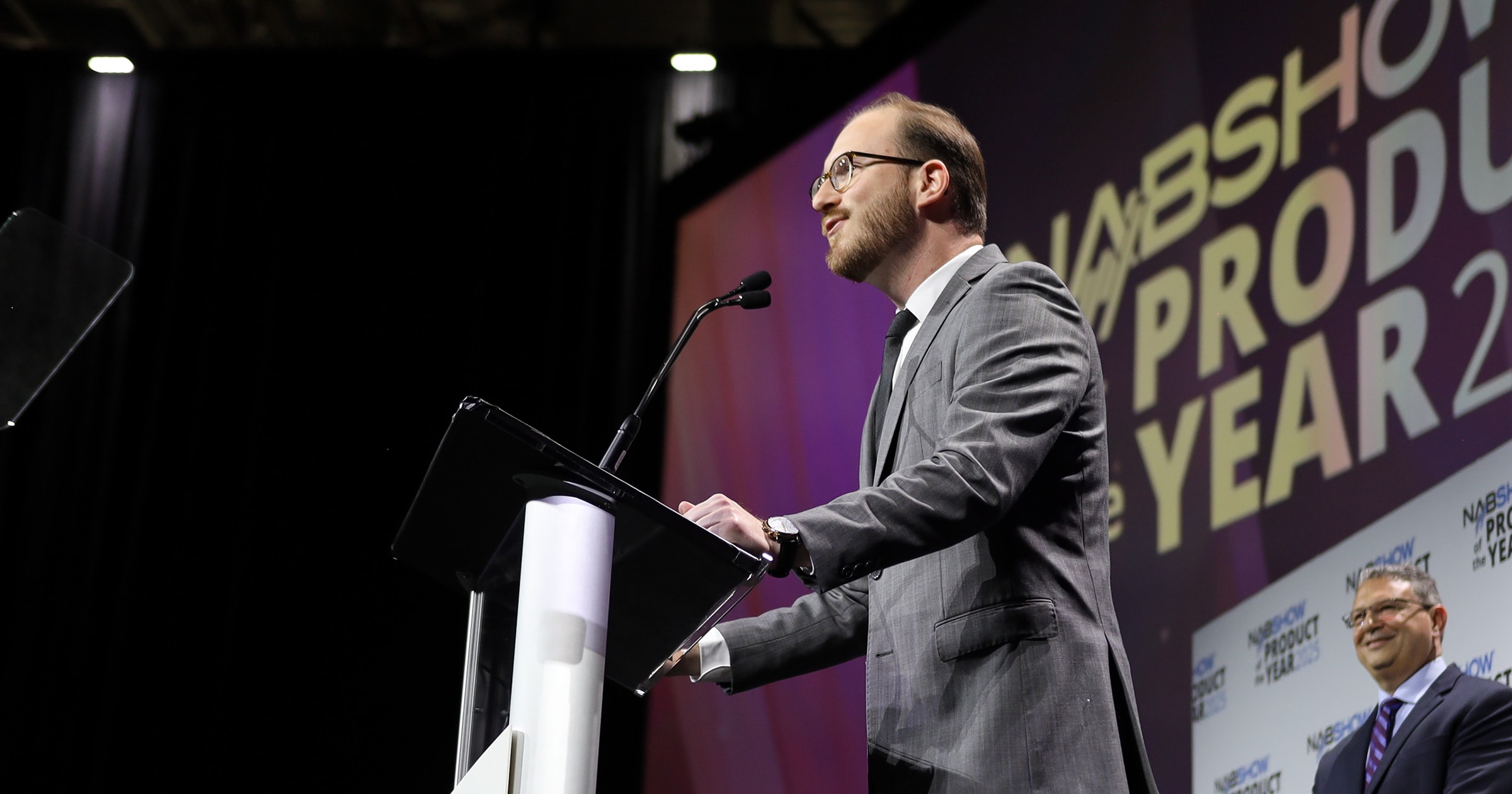 A man stands at the podium during the 2025 NAB Show Product of the Year Awards Ceremony. 